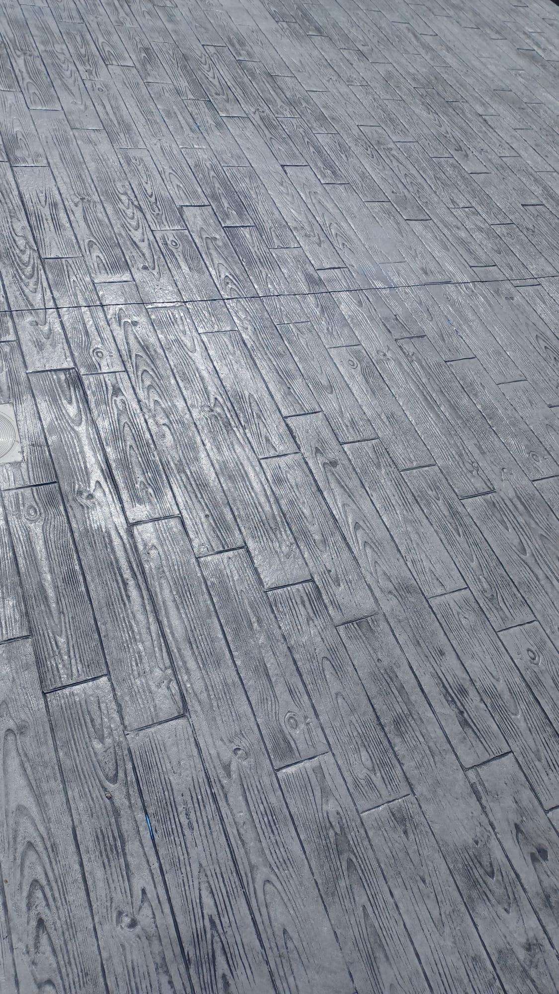 Zona de aparcamiento con pavimento hormigón impreso tono gris claro