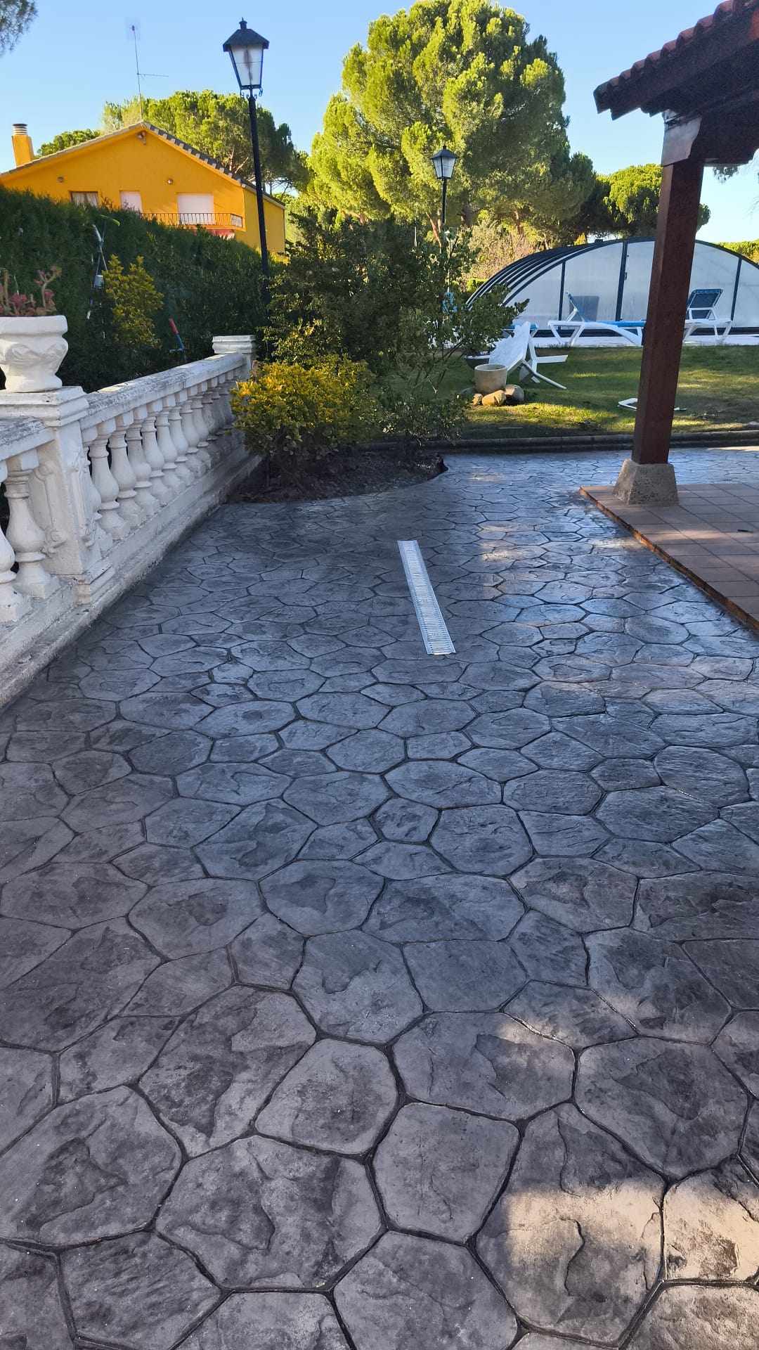 Suelo exterior hormigón impreso color ocre y base beige en jardín